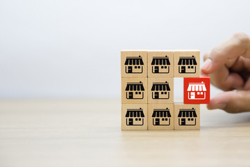 Franchise business,Businessman hand choose wooden blog with franchise marketing icons Store.