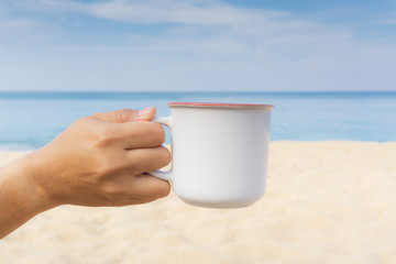 Asian woman hands hold hot coffee mug outdoor on clear sky background with copy space. Enjoy drinking coffee in the morning.