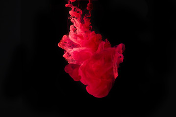 Studio shot of colored ink in water isolated on black background