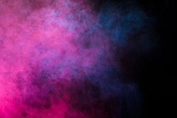 Fototapeta premium Freeze motion of colored dust explosion isolated on black background.