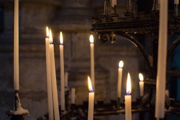 Close up of candles burning inside the Saint Bavo Cathedral (or Sint-Baafs Cathedral) in Ghent, Belgium, Europe. Spirituality.