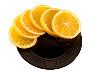 orange slices on a black plate on white backgrond