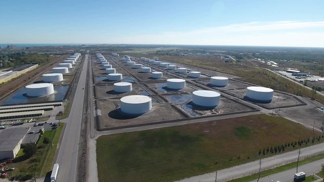White oil refinery storage tanks in rows aerial drone shot in Midwest, United States