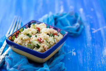 tabbouleh in small bowl on blue wooden background