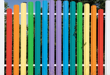 multi-colored aluminum high railing against the blue sky and adult green spaces