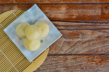 Top view. Thai style Mochi stack on white plate  and wooden table with copy space for your text. Thai sweet dessert.
