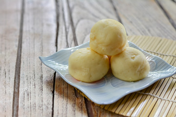 Thai style Mochi stack on white plate  and wooden table with copy space for your text. Thai sweet dessert.