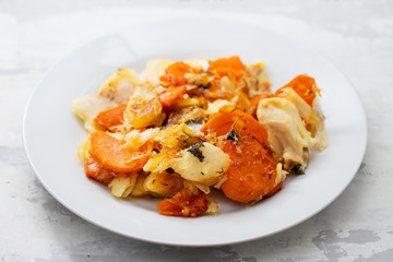 fried cod fish with sweet potato on white dish on ceramic background
