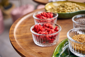 on a wooden table is a glass ceramic dish with healthy dried fruits