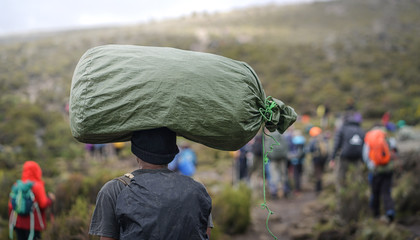 Porter Carrying Heavy Stuff On His Head, Climbing Mount Kilimanjaro, Mount Kilimanjaro National...