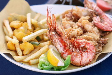 Fried seafood and vegetables on a white plate. Close-up