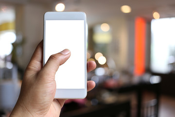 Hand of a man holding smart phone device in the coffee cafe background.