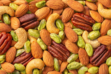 food background of unsalted mixed nuts, top view