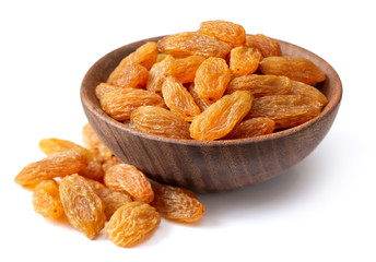 yellow raisins in the wooden bowl, isolated on white background