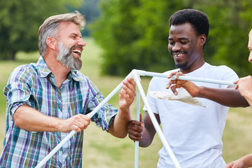 Friends build a tent together