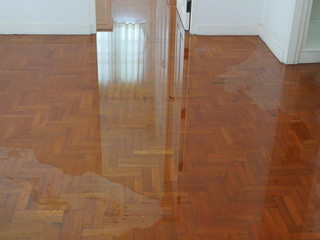 Water spreading / flooding on the parquet floor of a house - damage caused by water leakage