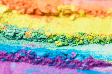 A broken rainbow colored eye shadow smear, make up palette isolated on a white background.