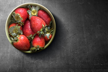 Strawberry in the bowl on a black background