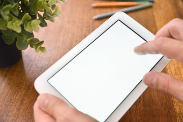Hands using white tablet with white screen on desk elevated