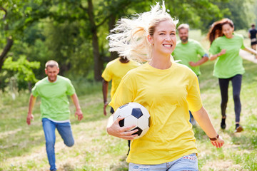 Naklejka premium Young woman with soccer ball in a race