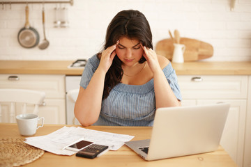 Stressful depressed young overweight woman facing financial problems, having frustrated look,...