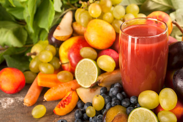 Healthy organic fresh multivitamin fruit juice with seasonal fruit decoration on rustic wooden table