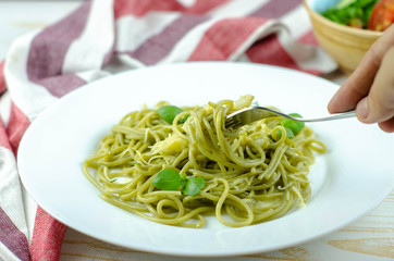 green spinach spaghetti with basil and cheese