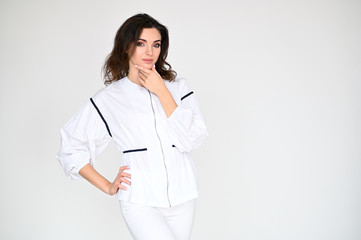 Concept photo portrait of a cute pretty beautiful brunette girl with great makeup in white clothes on a white background. In different poses with emotions.