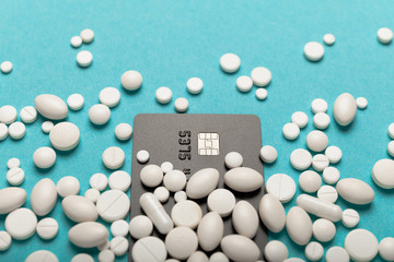 Credit card and medicines (pills). High cost of treatment in hospital, expensive medications concept.