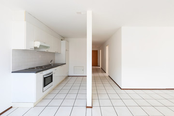 Empty room with vintage kitchen, white tiles and walls