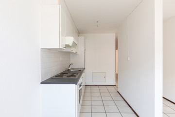 Empty room with vintage kitchen, white tiles and walls