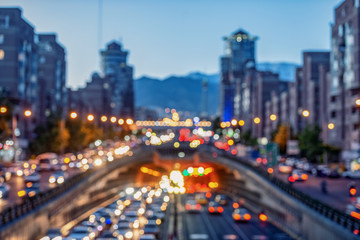 Fototapeta na wymiar Blurred and Famous view of Tehran,Flow of traffic around Tohid Tunnel with Milad Tower and Alborz Mountains in Background, night cityscape concept