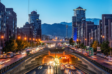 Fototapeta na wymiar 06/05/2019 Tehran,Iran,Famous night view of Tehran,Flow of traffic round Tohid Tunnel with Milad Tower and Alborz Mountains in Background, Tohid Tunnel one of longest urban tunnel in Middle East