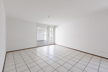 Front view of empty room with white walls and tiles