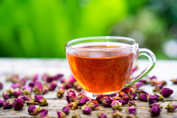 Damask rose bud,tTea for holistic health,tea made from tea rose petals in a glass  on wooden background