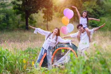 group of warm family enjoy playing together in wildflowers meadow field at light of sun nature.