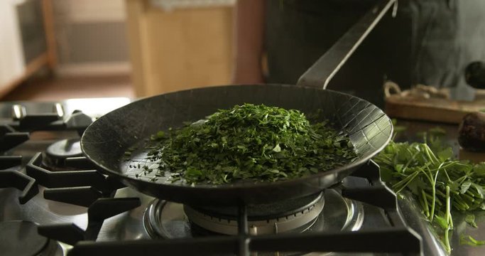 Woman steaming parsley for Maultaschen filling