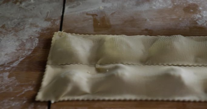 Woman using pastry wheel for cutting home made Maultaschen