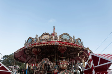 Gorgeous vintage carousel in an amusement park on a background a blue sky. Amusement park in Spain.