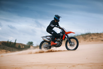 Fototapeta na wymiar Motorcyclist on a cross-country motorcycle go fast at the dune