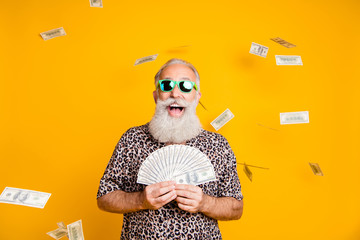 Photo of elderly old confident rich man holding banknotes in his hands and being rained with...