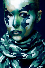 Beautiful young fashion woman with military style clothing and face paint make-up, khaki colors, halloween celebration