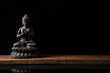 Statue of Buddha sitting in meditation With black copy space . Zen and meditation concept.