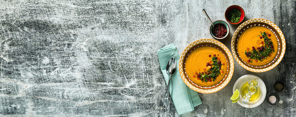 banner of Turkish red lentil soup in national plates on a stone table. shot from above
