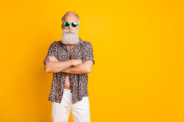 Photo of old confident man seeming to be businessman having rest abroad while isolated with yellow background
