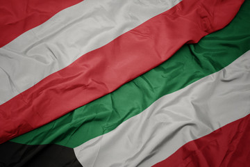 waving colorful flag of kuwait and national flag of austria.
