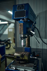 Equipment for drilling holes in a motorcycle workshop.