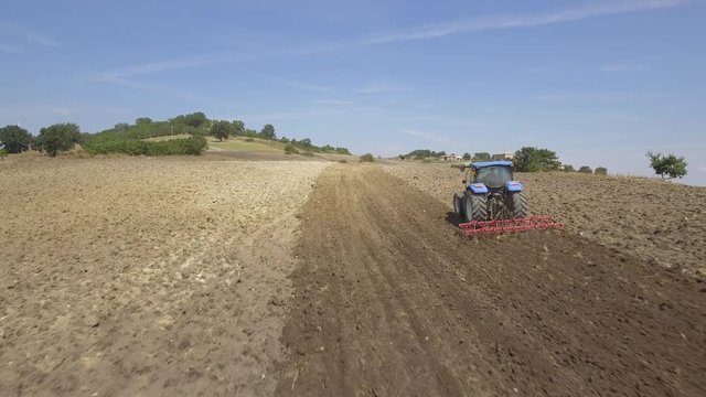 Farmer on tractor plowing a field in Umbria, Italy