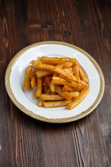 French fries on a white round plate. Restaurant menu