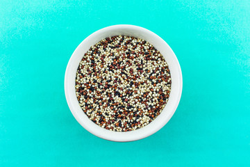 quinoa in bowl on green background.